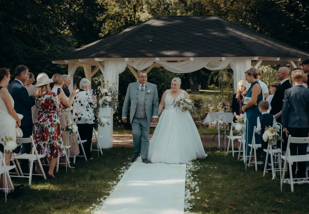 Hochzeit im Freien, Brautpaar und Gäste feiern bei schönem Wetter unter einem festlichen Pavillon im Schloss . Hochzeitsfoto Altmark Christian Riemann